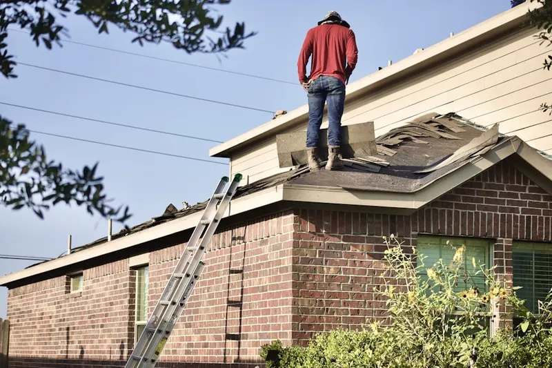 Professional roofer working on a residential roof in Blodgett